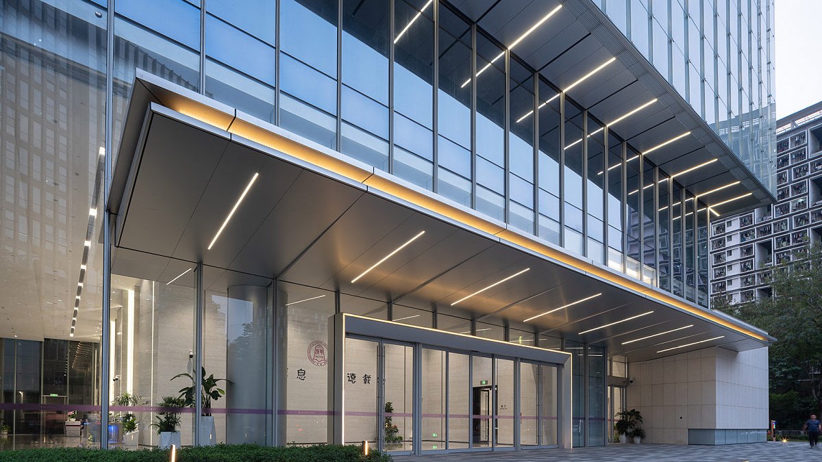 Building entrance with a broad metal canopy and integrated lighting