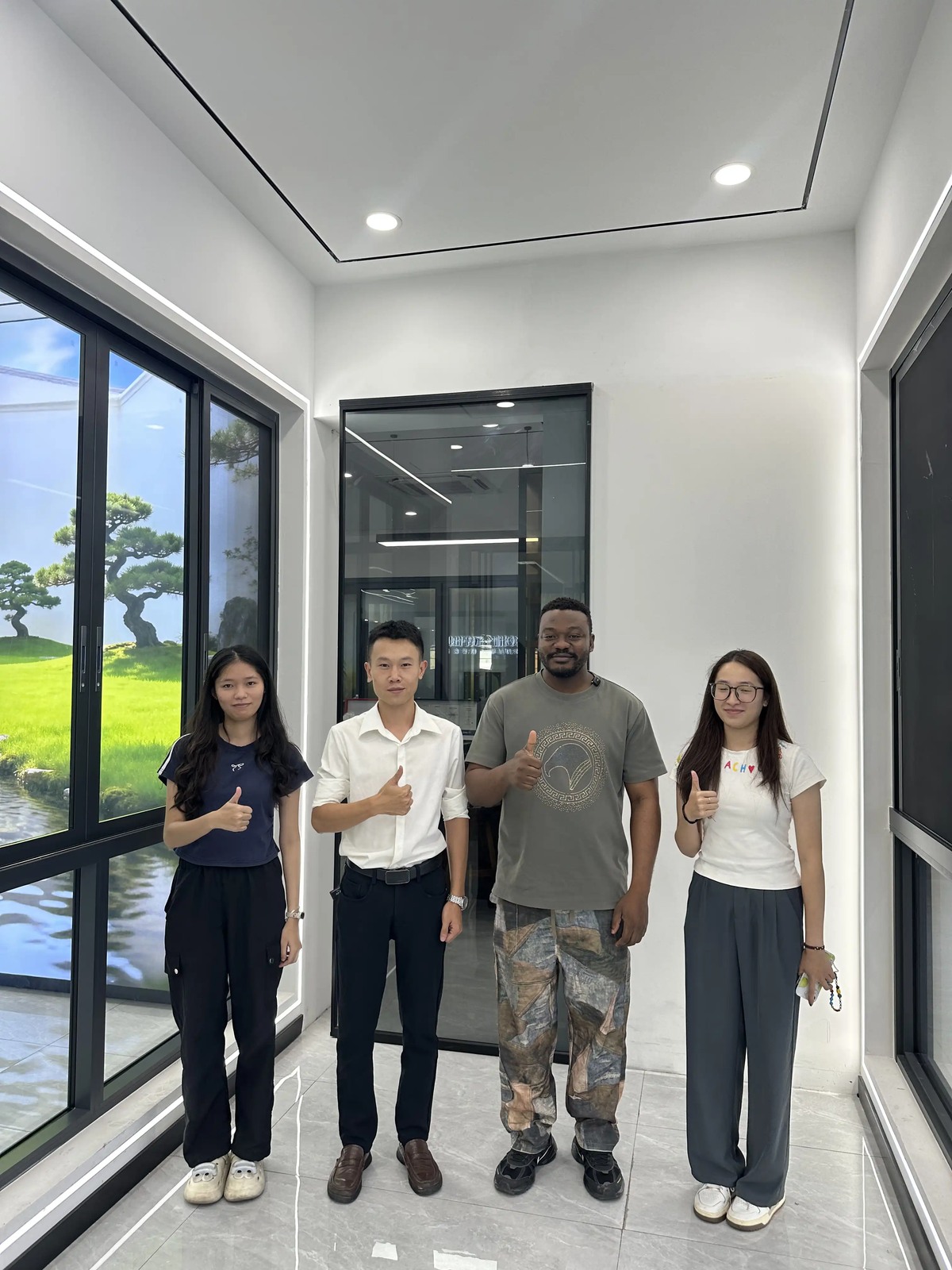 Four people standing together in the Guantian showroom during a customer visit