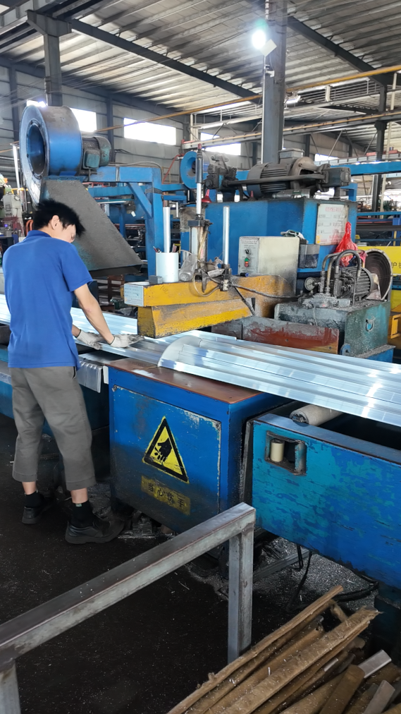 Aluminum profile being cut to length at a saw.