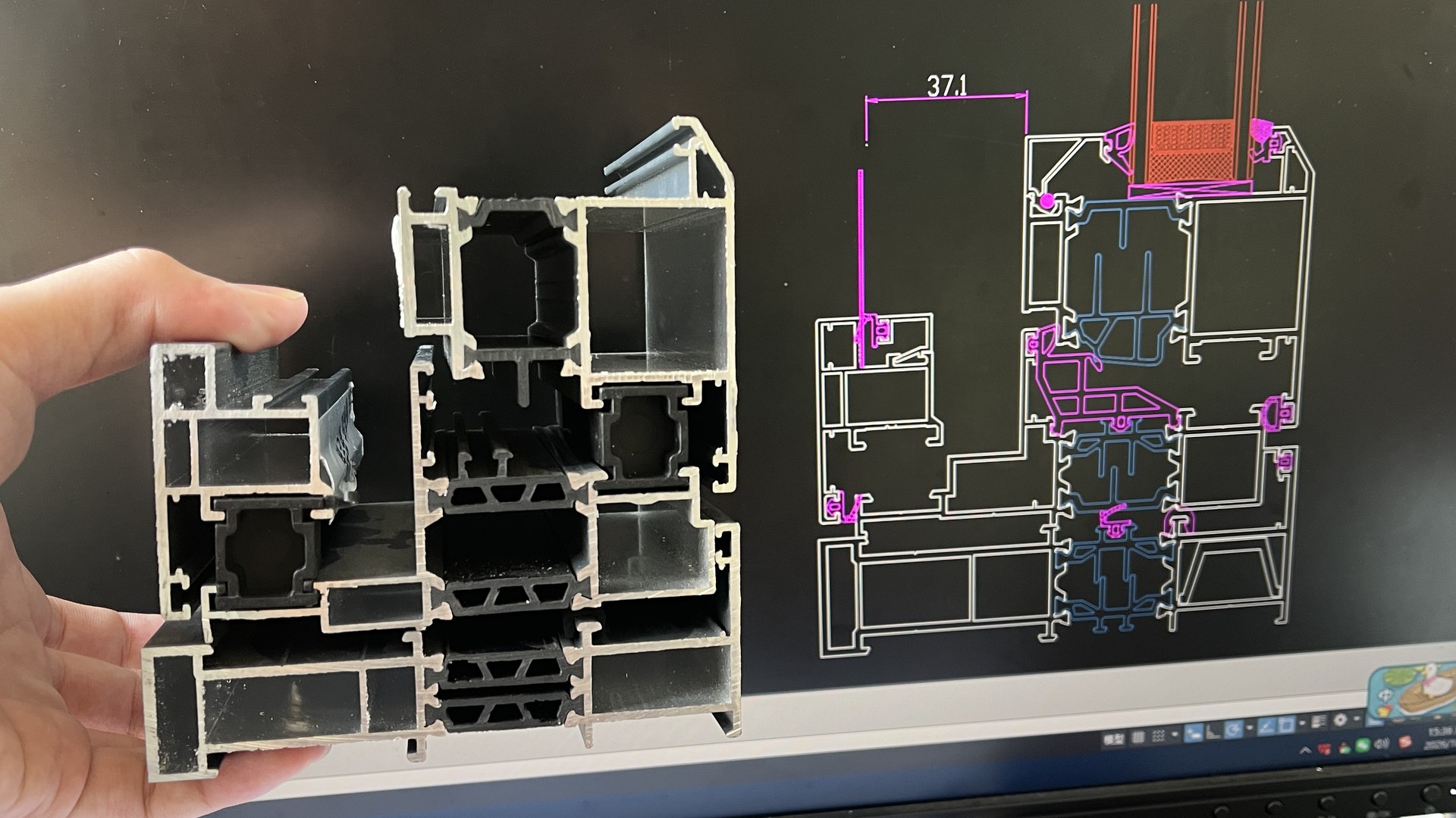 Aluminum profile section held beside its matching CAD cross-section drawing